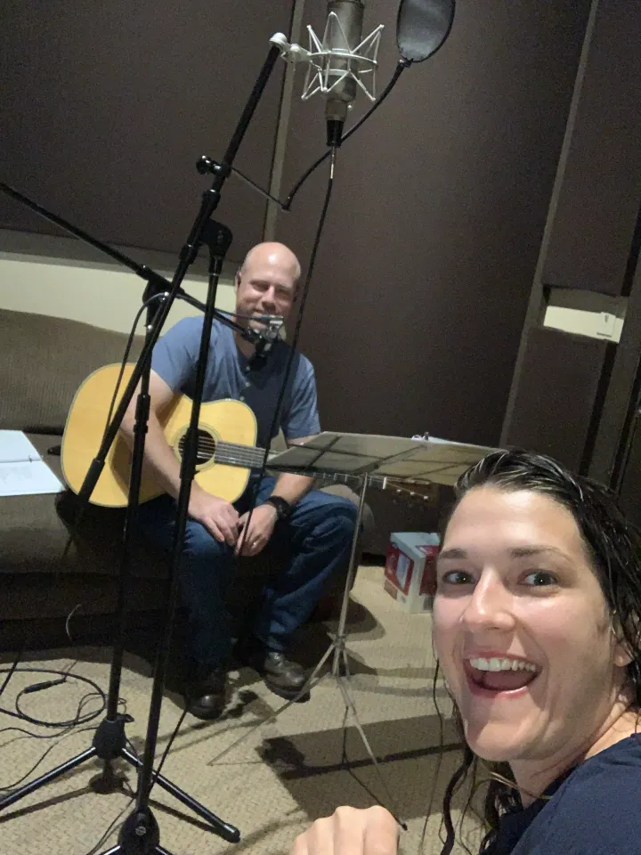 Sam playing guitar in the recording studio with Ronni in the foreground.