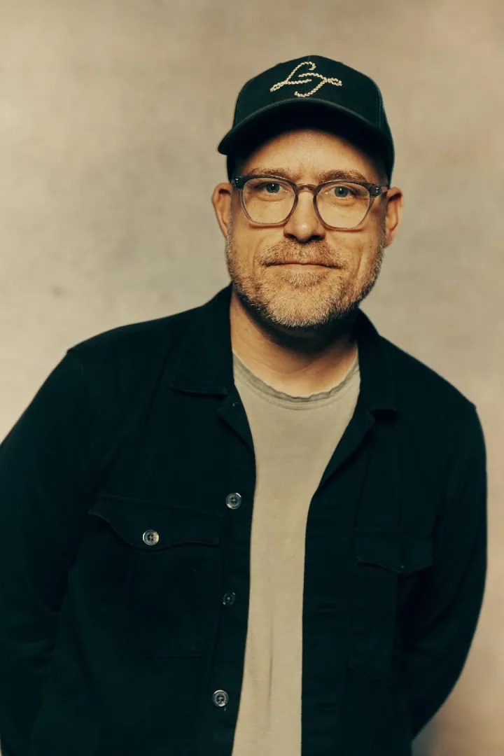 Portrait of Ben Shive wearing glasses and a cap.